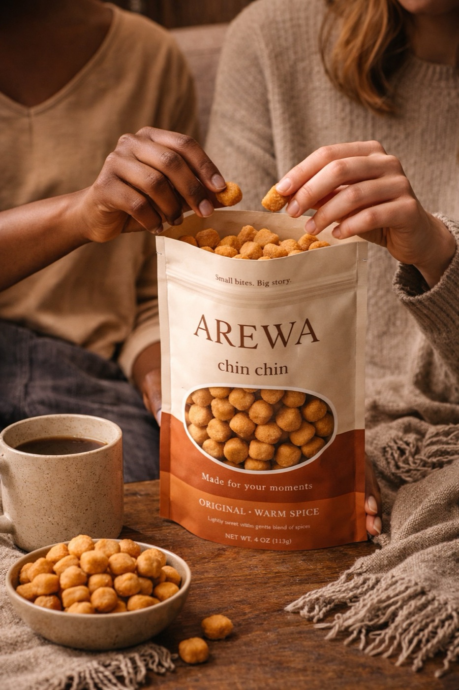 Two hands reaching into an open bag of Arewa Chin Chin — the image this brand is built on